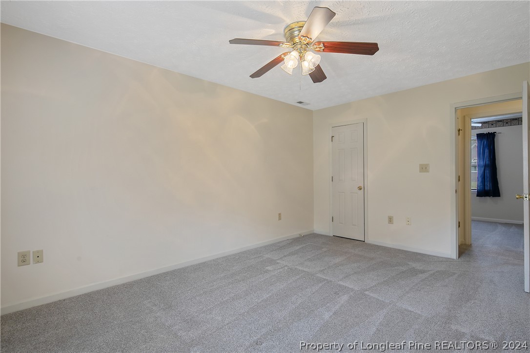 51 Overlook Road Cameron, NC 28326 - Photo 21 of 40 an empty room with a chandelier fan and a ceiling fan