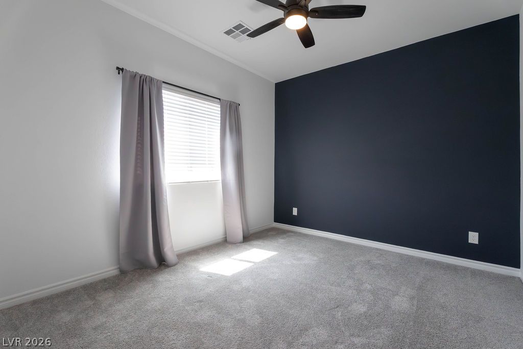 7126 Calvert Cliffs Street North Las Vegas, NV 89084 - Photo 34 of 44 A well-lit bedroom features plush carpeting and a modern ceiling fan, creating a comfortable atmosphere.