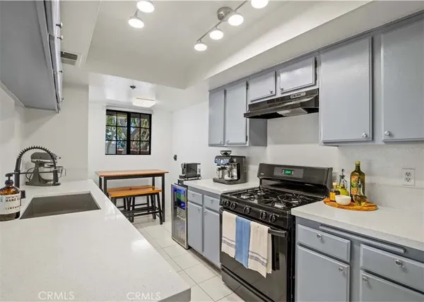 a kitchen with stainless steel appliances a stove a sink a stove and cabinets