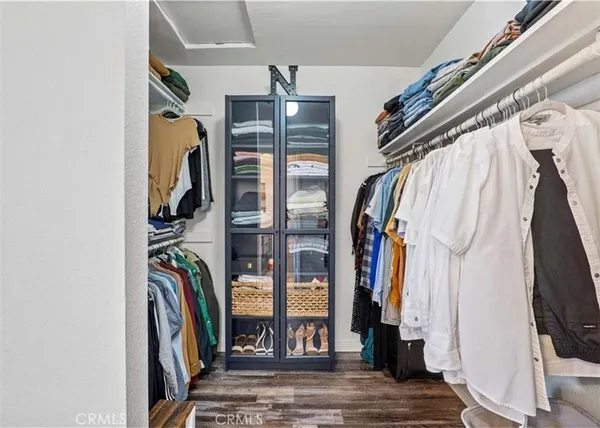a view of walk in closet with clothes and shoes