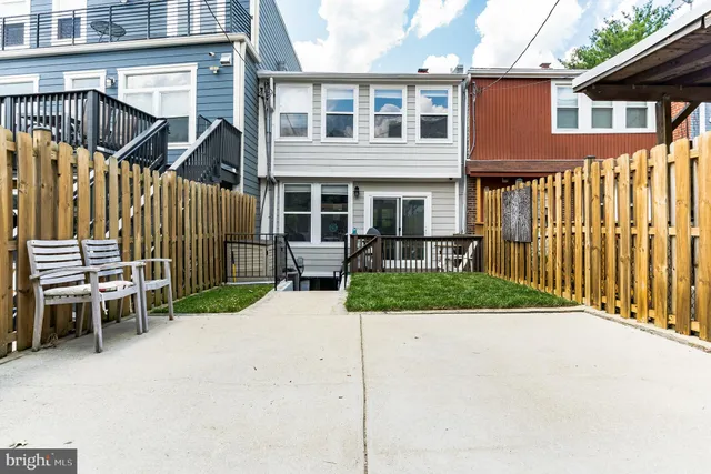 a view of a house with a small yard and wooden fence