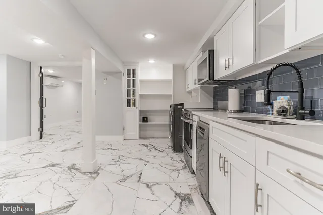 a kitchen with stainless steel appliances kitchen island granite countertop a refrigerator and a sink