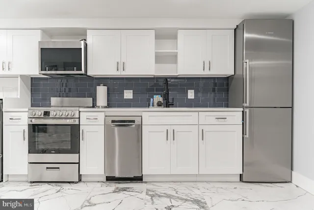 a view of kitchen with refrigerator sink and cabinets