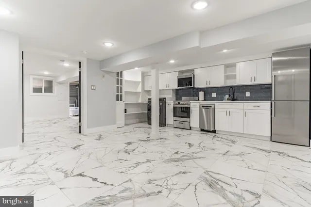 a kitchen with stainless steel appliances kitchen island granite countertop a refrigerator sink and cabinets