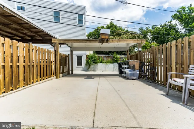 a view of a patio with table and chairs with wooden fence