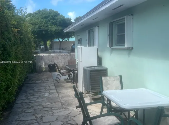 a backyard of a house with table and chairs