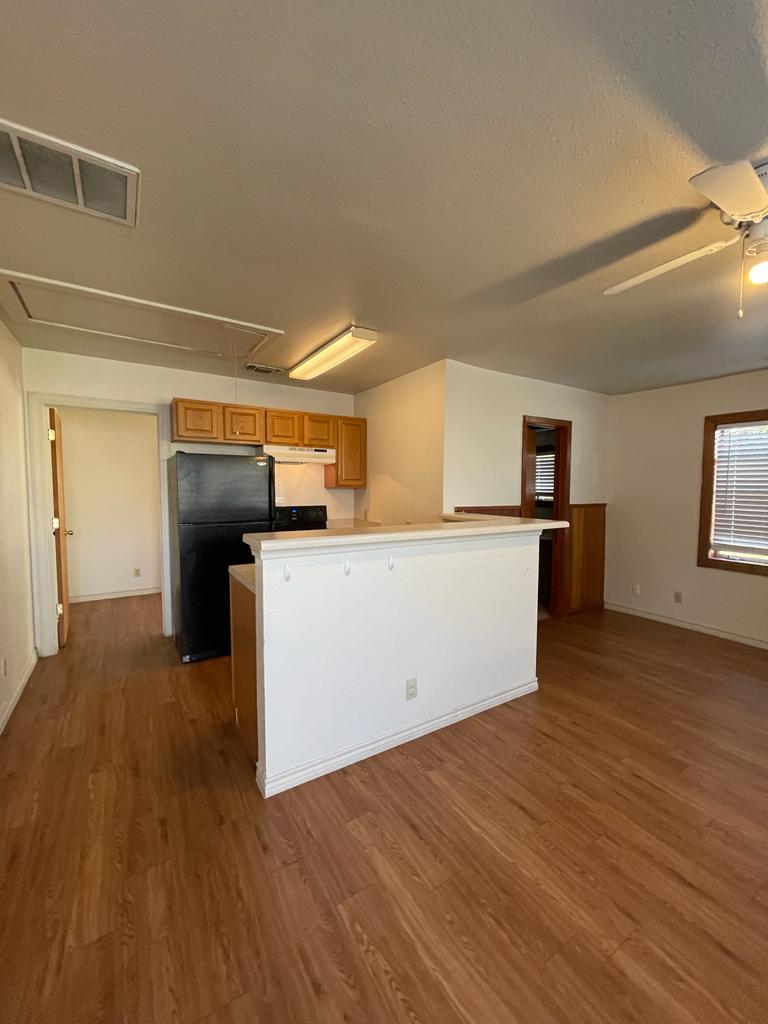 108 Austin Street, Unit B Kyle, TX 78640 - Photo 7 of 14 A well-appointed kitchen and living area, complete with sleek flooring and natural light.