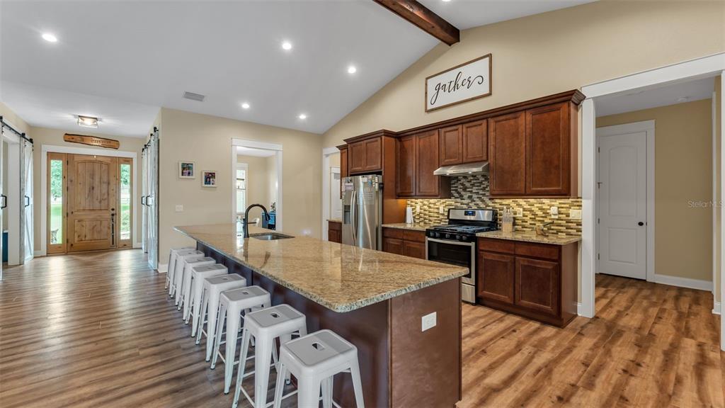 3430 North Galloway Road Lakeland, FL 33810 - Photo 14 of 84 a kitchen with stainless steel appliances granite countertop a refrigerator a stove top oven a sink dishwasher and wooden cabinets with wooden floor