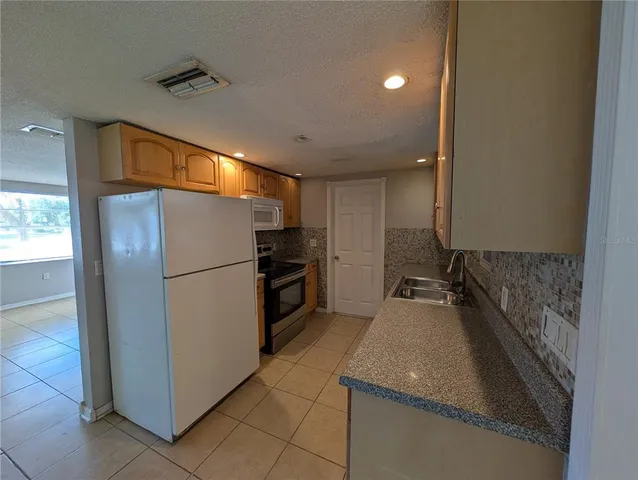 a kitchen with a refrigerator and a sink