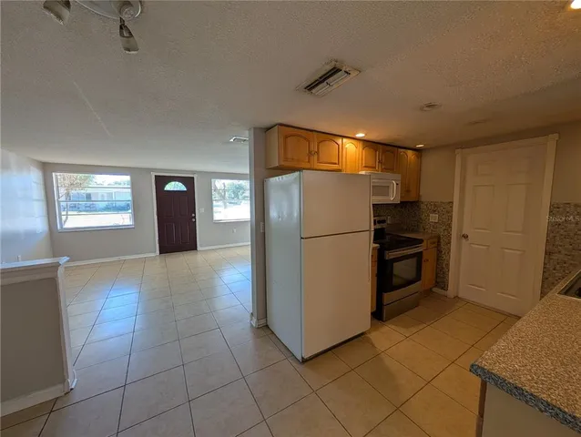 a kitchen with a refrigerator and a stove top oven