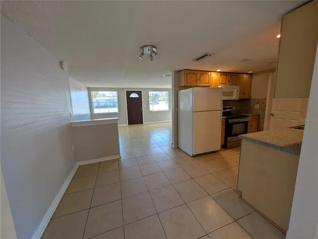 a view of a refrigerator in kitchen and a sink