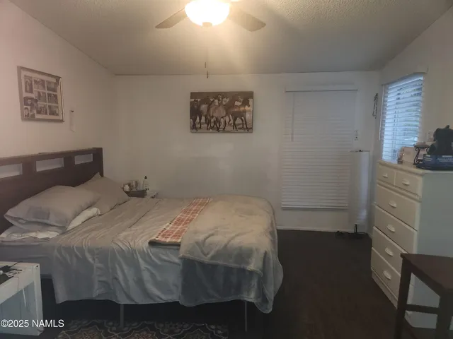a bedroom with a bed and a flat tv screen on dresser