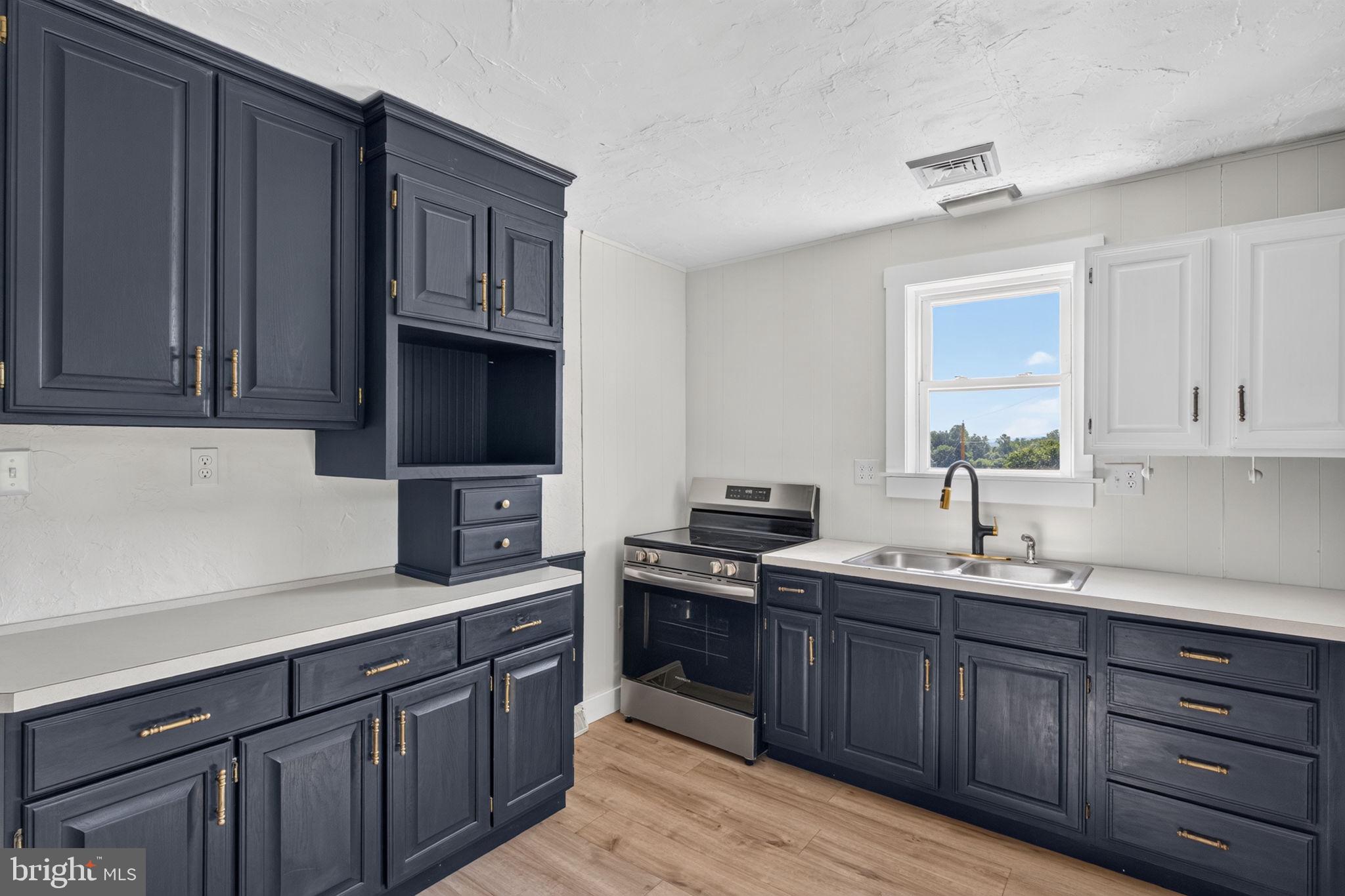 140 Limekiln Road Reading, PA 19606 - Photo 23 of 37 a kitchen with stainless steel appliances granite countertop a sink dishwasher stove and cabinets with wooden floor