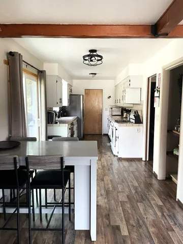 a kitchen with kitchen island a refrigerator stove microwave and sink
