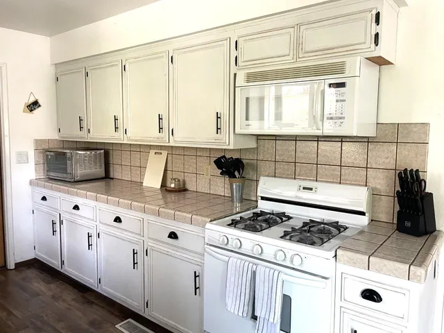 a kitchen with stainless steel appliances a stove a sink and a microwave