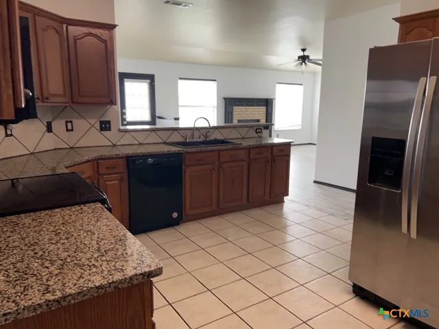 a kitchen with stainless steel appliances granite countertop a refrigerator and a stove