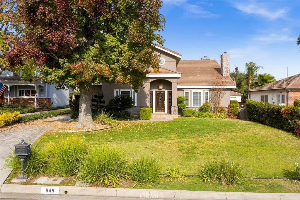 a view of a house with backyard and tree