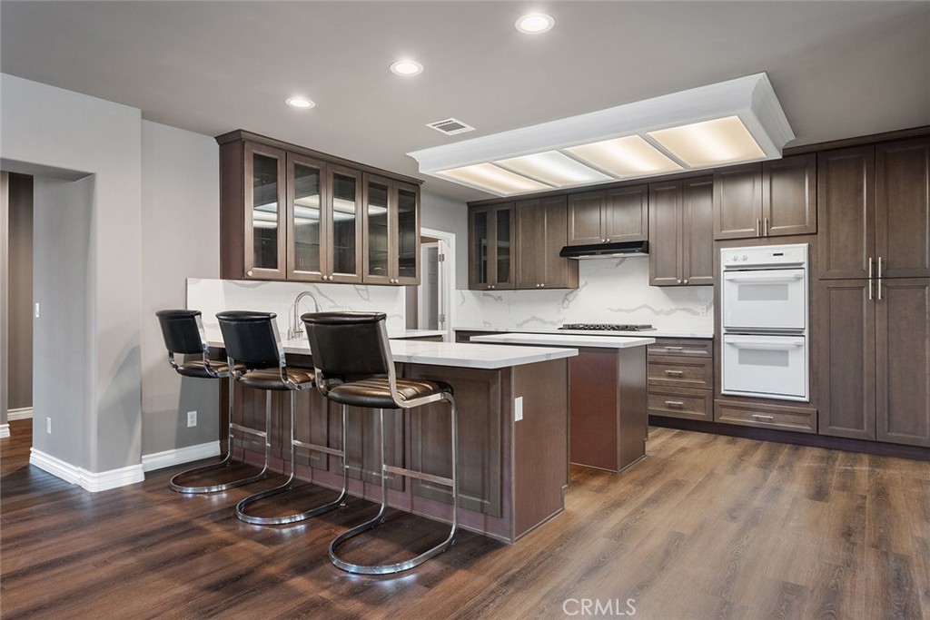 849 Balboa Drive Arcadia, CA 91007 - Photo 23 of 54 a kitchen with stainless steel appliances granite countertop a sink cabinets and wooden floor