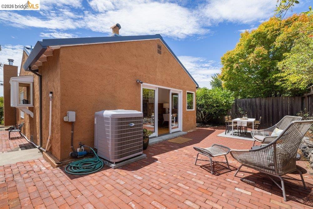 287 Purdue Avenue Kensington, CA 94708 - Photo 38 of 60 Expansive brick paver patio featuring a stucco exterior, sliding glass door access, and a wood privacy fence