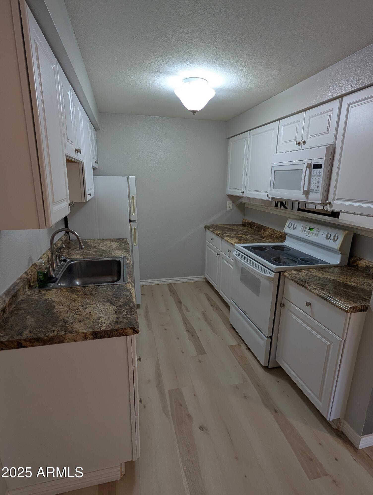 1440 North Idaho Road, Unit 2050 Apache Junction, AZ 85119 - Photo 6 of 21 a kitchen with a sink stove and cabinets