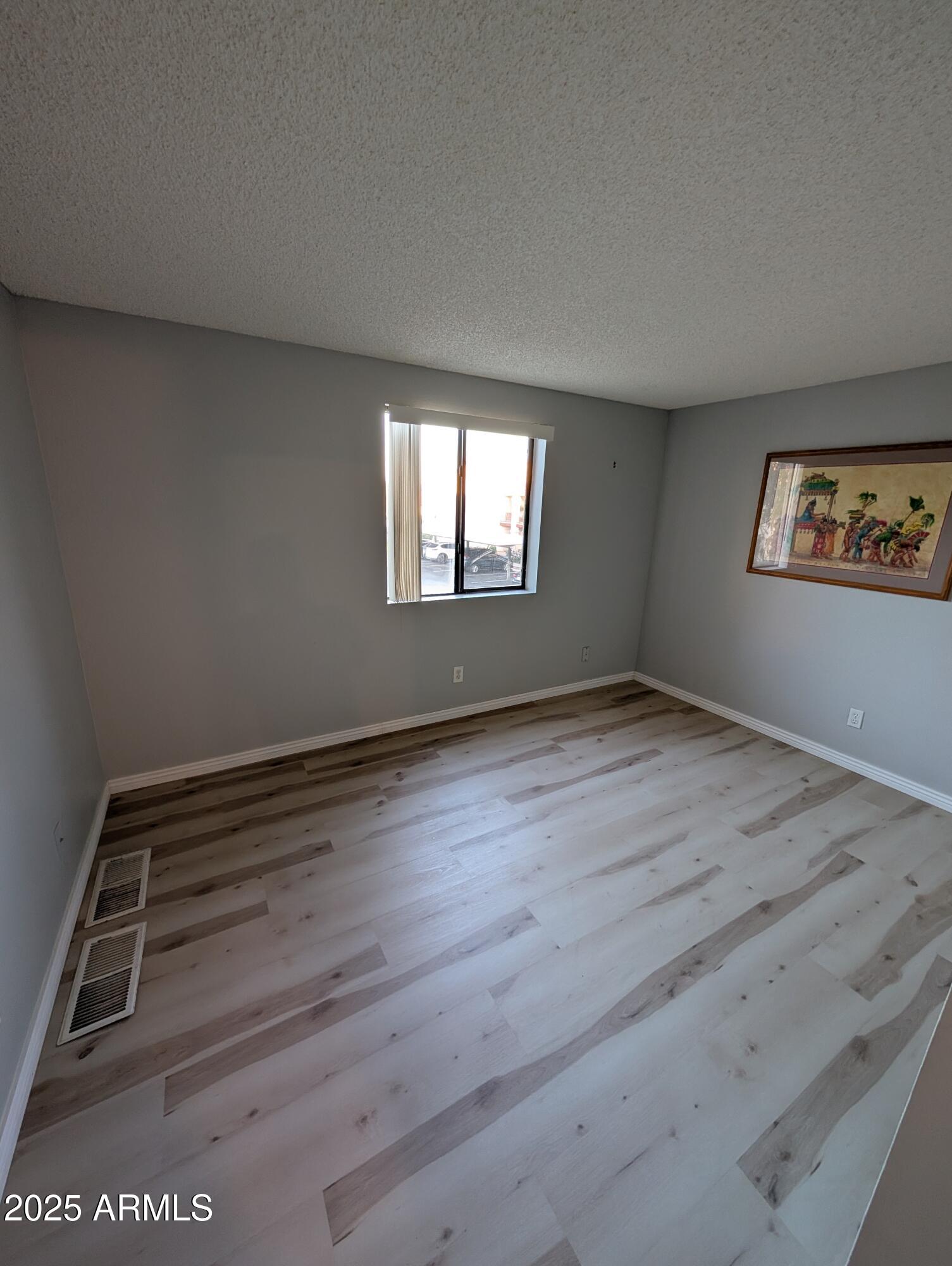 1440 North Idaho Road, Unit 2050 Apache Junction, AZ 85119 - Photo 8 of 21 an empty room with wooden floor and windows
