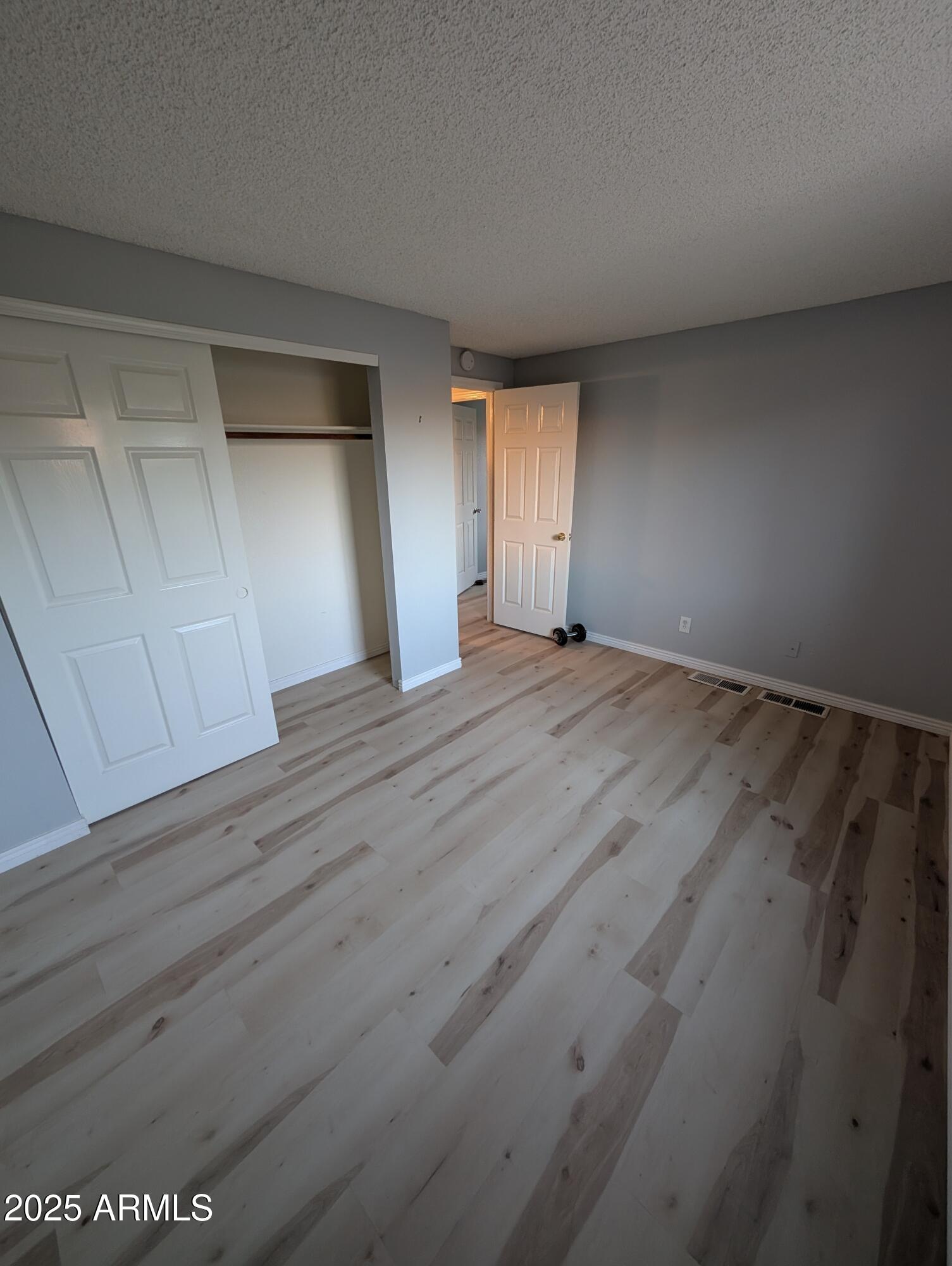 1440 North Idaho Road, Unit 2050 Apache Junction, AZ 85119 - Photo 9 of 21 a view of an empty room with wooden floor and a window