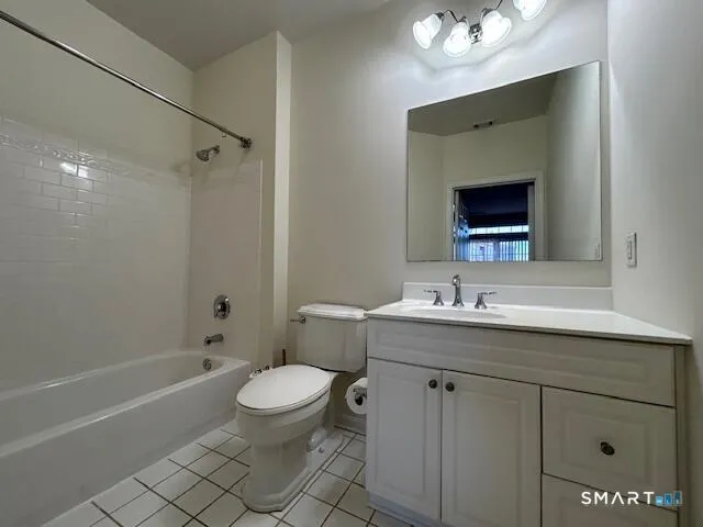 a bathroom with a toilet a sink a mirror a bathtub and vanity