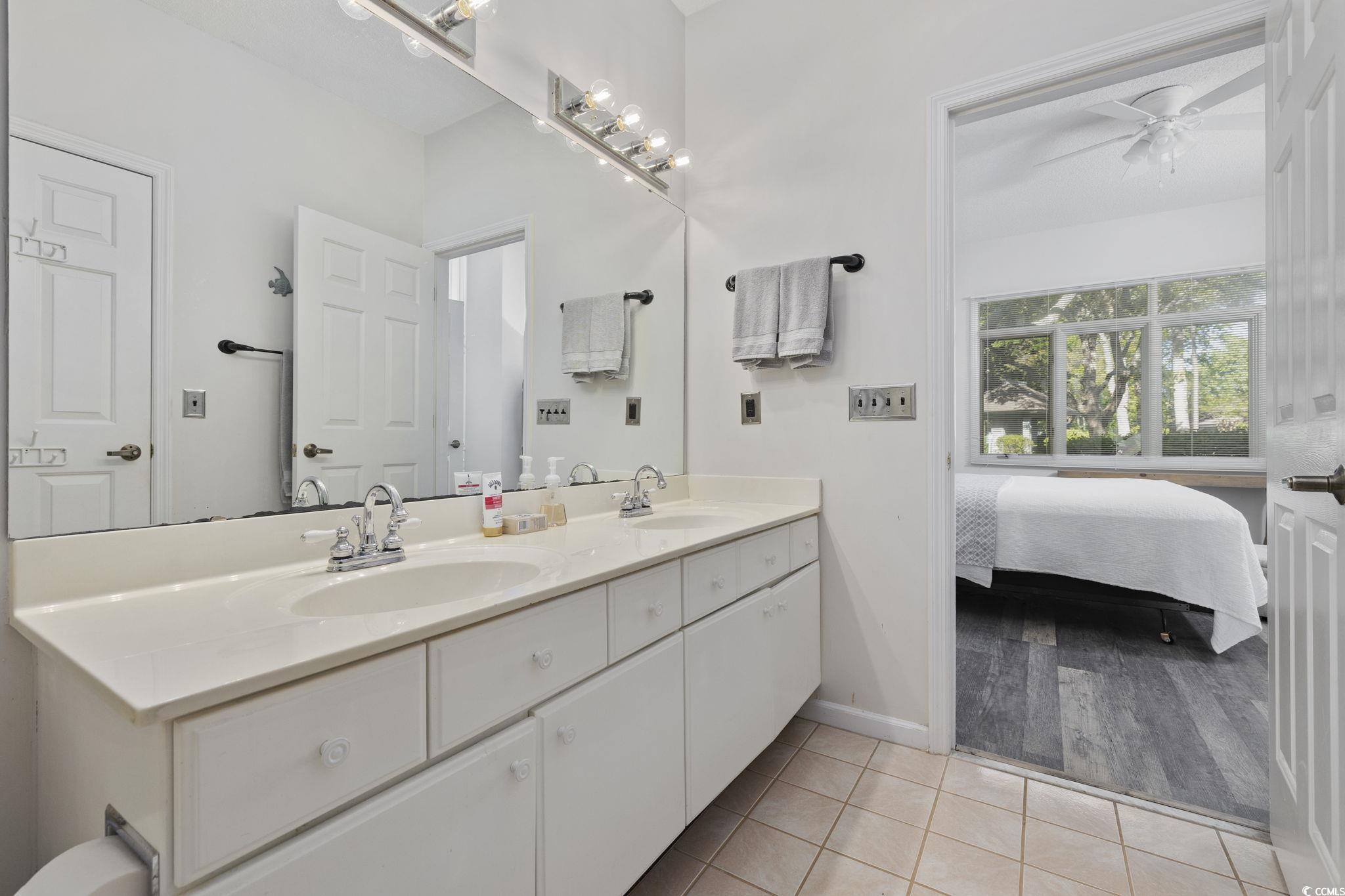 1221 Tidewater Drive, Unit 412 North Myrtle Beach, SC 29582 - Photo 19 of 36 Full bath with double vanity, light tile patterned floors, ensuite bath, and a ceiling fan