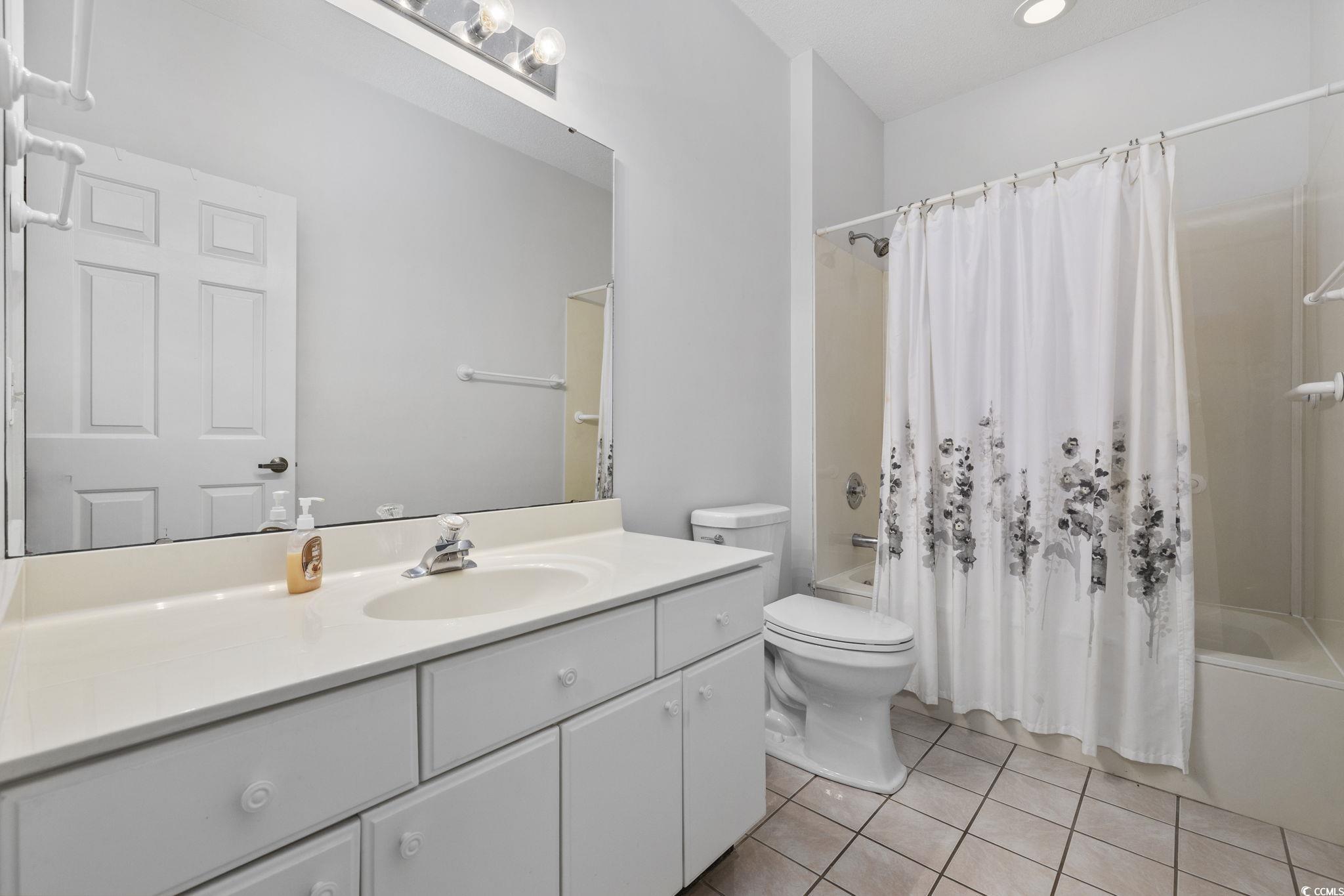 1221 Tidewater Drive, Unit 412 North Myrtle Beach, SC 29582 - Photo 22 of 36 Bathroom featuring shower / tub combo, vanity, and light tile patterned floors