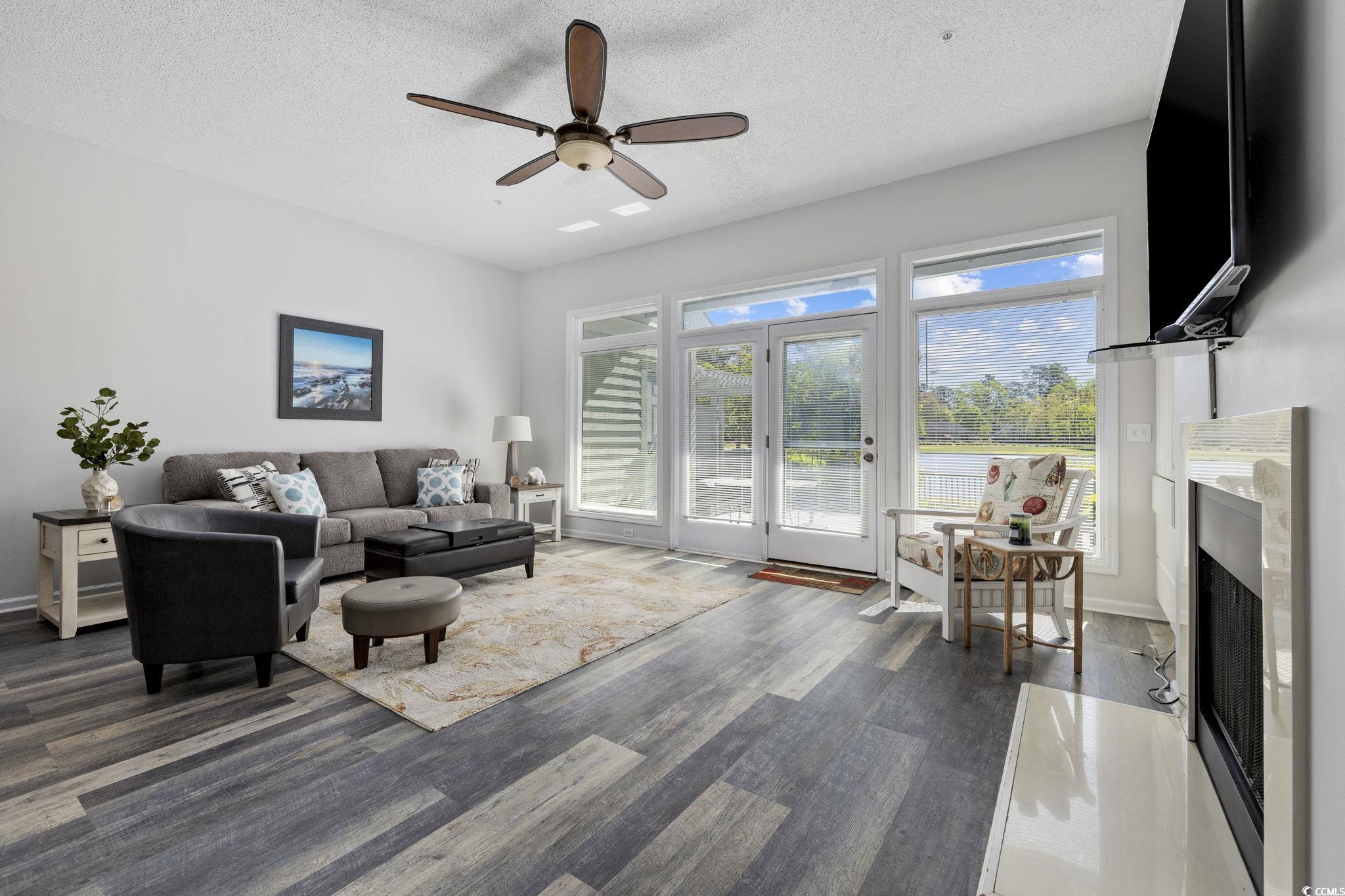 1221 Tidewater Drive, Unit 412 North Myrtle Beach, SC 29582 - Photo 10 of 36 Living area with a premium fireplace, dark wood-type flooring, a textured ceiling, and a ceiling fan