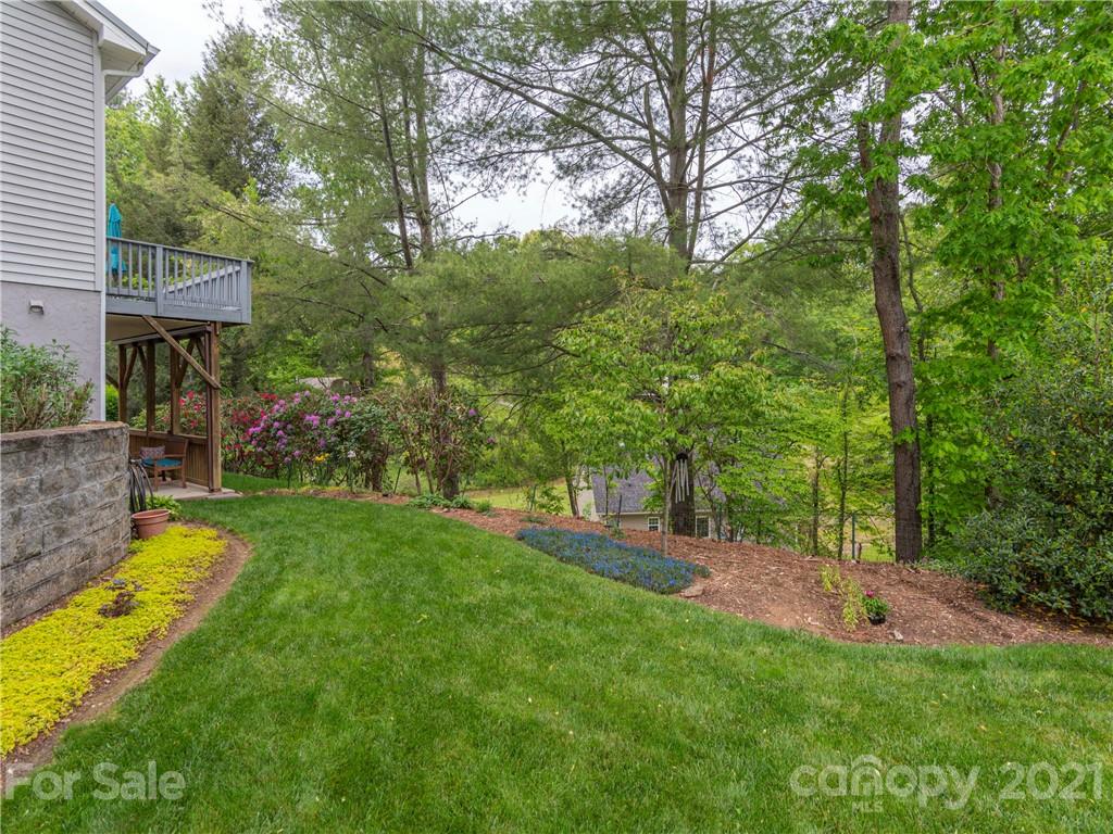 100 Ridgeline Road Clyde, NC 28721 - Photo 23 of 26 a view of a backyard with a garden and trees