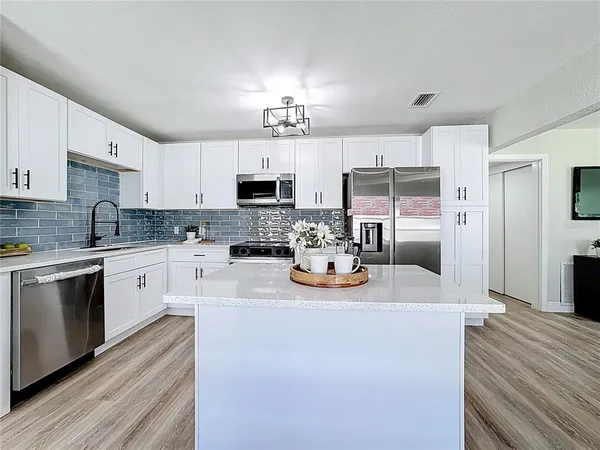 a kitchen with kitchen island granite countertop a sink stove and refrigerator