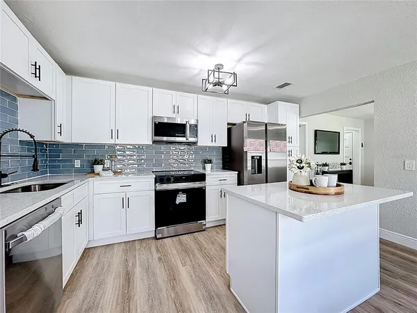 a kitchen with stainless steel appliances a stove microwave and refrigerator