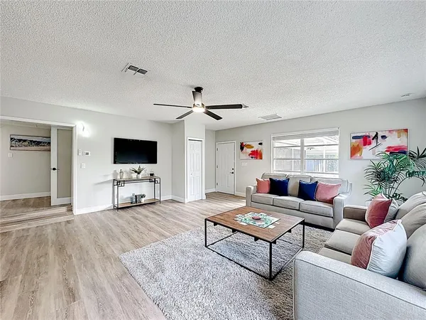 a living room with furniture and a wooden floor