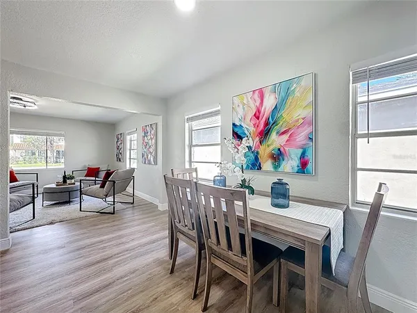 a view of a dining room with furniture a rug and wooden floor