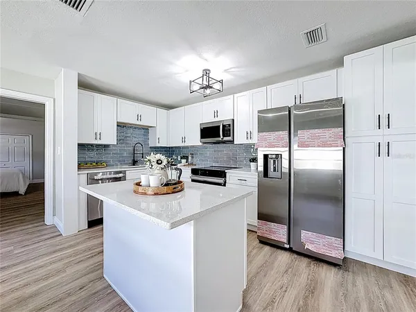 a kitchen with stainless steel appliances a refrigerator sink and microwave