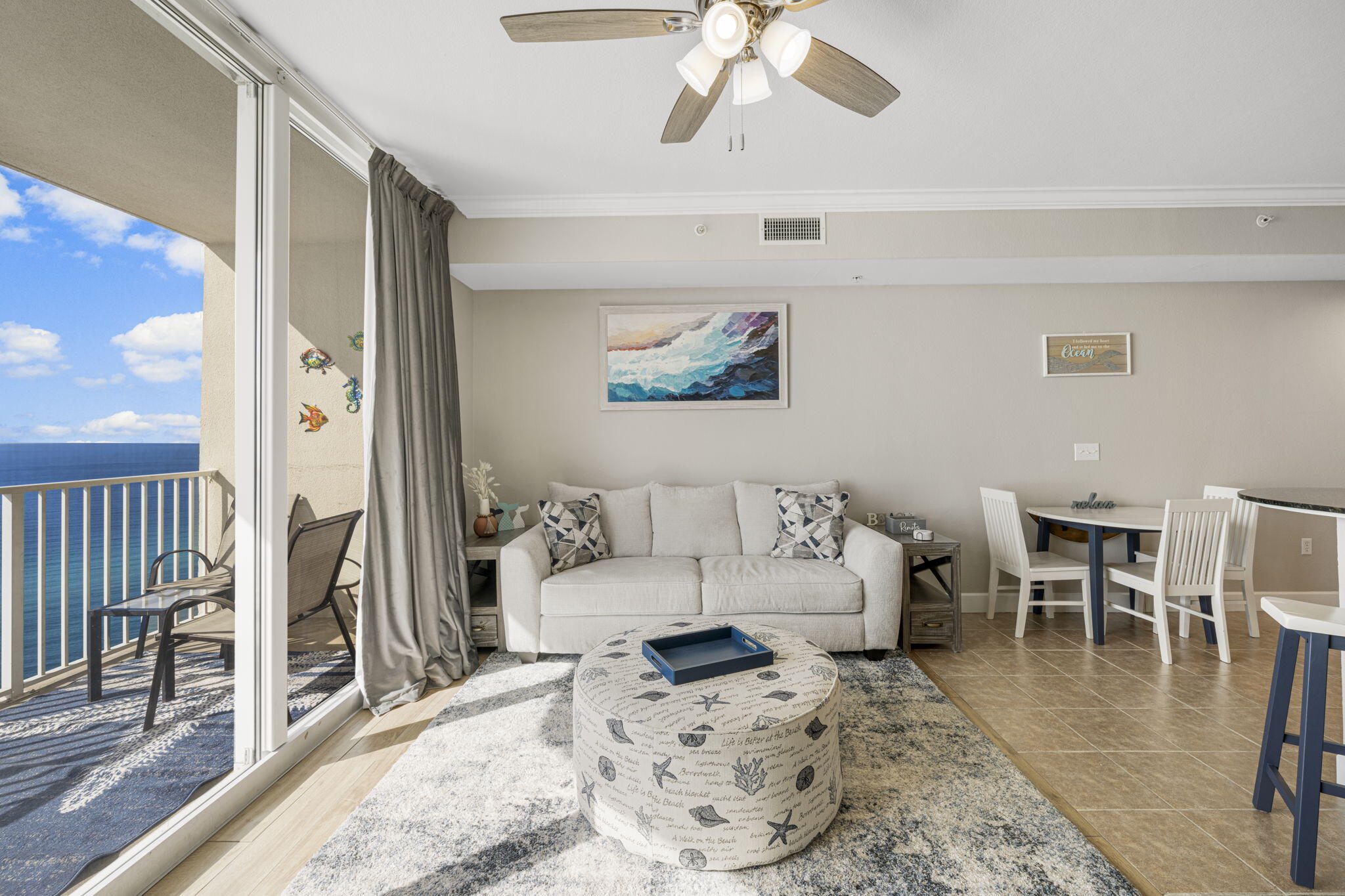 16819 Front Beach Road, Unit 2116 Panama City Beach, FL 32413 - Photo 3 of 51 a living room with furniture and a dining table with wooden floor