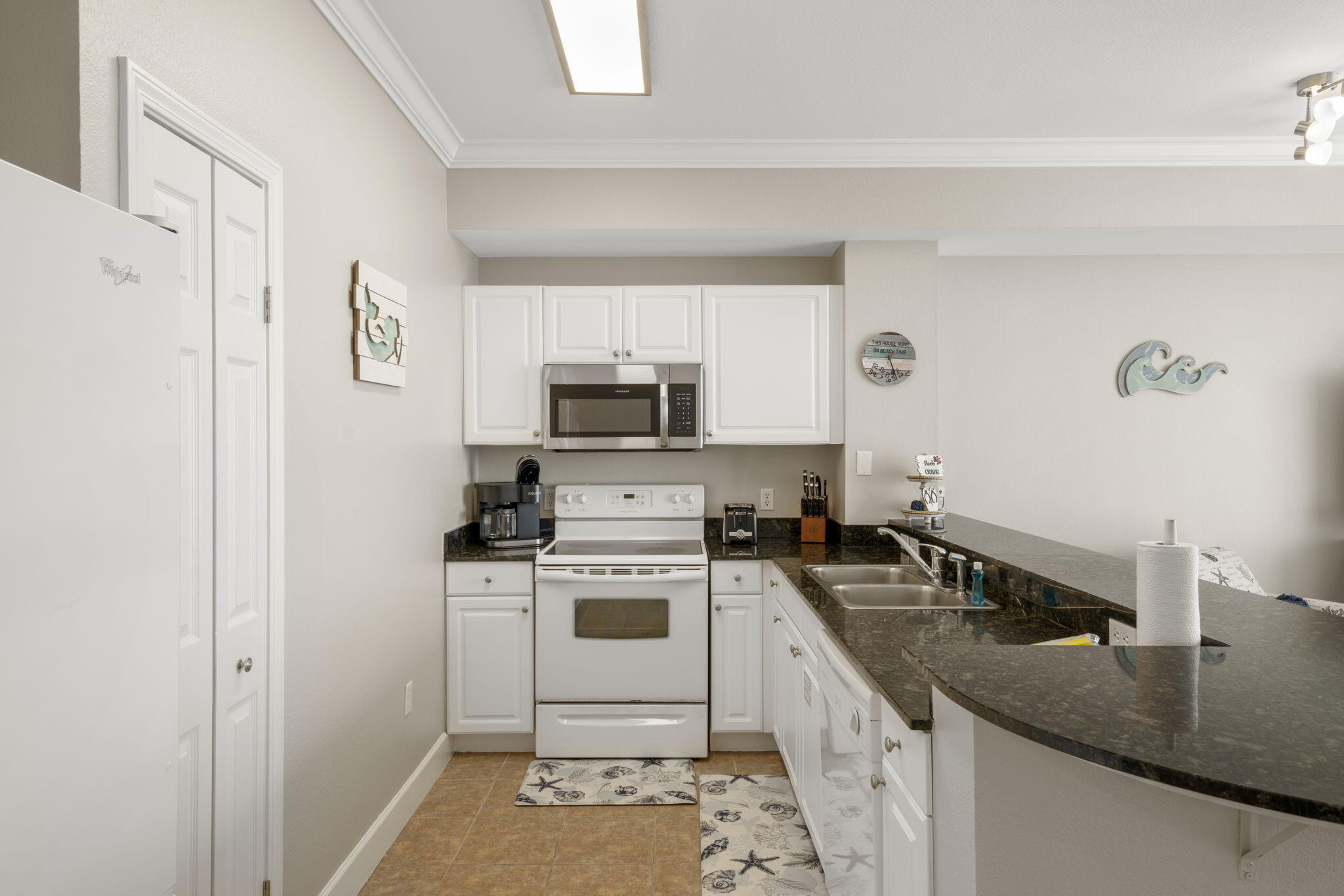16819 Front Beach Road, Unit 2116 Panama City Beach, FL 32413 - Photo 7 of 51 a kitchen with a sink stove and refrigerator