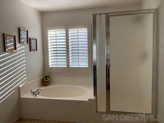38325 Encanto Road Murrieta, CA 92563 - Photo 14 of 17 a bathroom with a bathtub and a shower