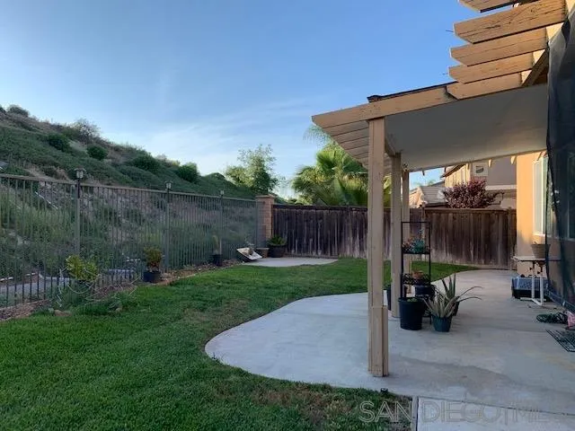 38325 Encanto Road Murrieta, CA 92563 - Photo 16 of 17 a view of a patio with table and chairs potted plants with wooden fence