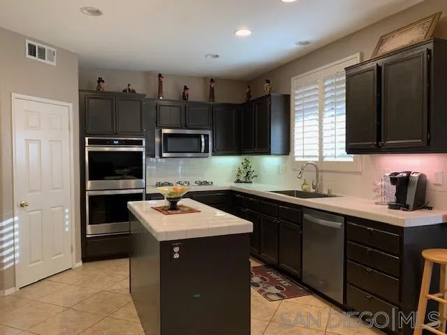 38325 Encanto Road Murrieta, CA 92563 - Photo 4 of 17 a kitchen with a sink stove top oven and cabinets