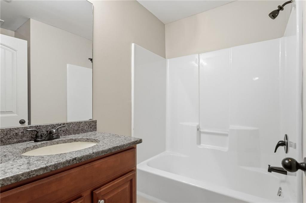 199 Mount Moriah Road Ball Ground, GA 30107 - Photo 19 of 39 a bathroom with a granite countertop sink and a bathtub