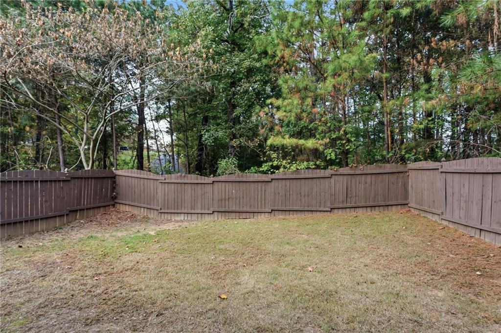 199 Mount Moriah Road Ball Ground, GA 30107 - Photo 36 of 39 a view of a backyard with a small yard and large trees