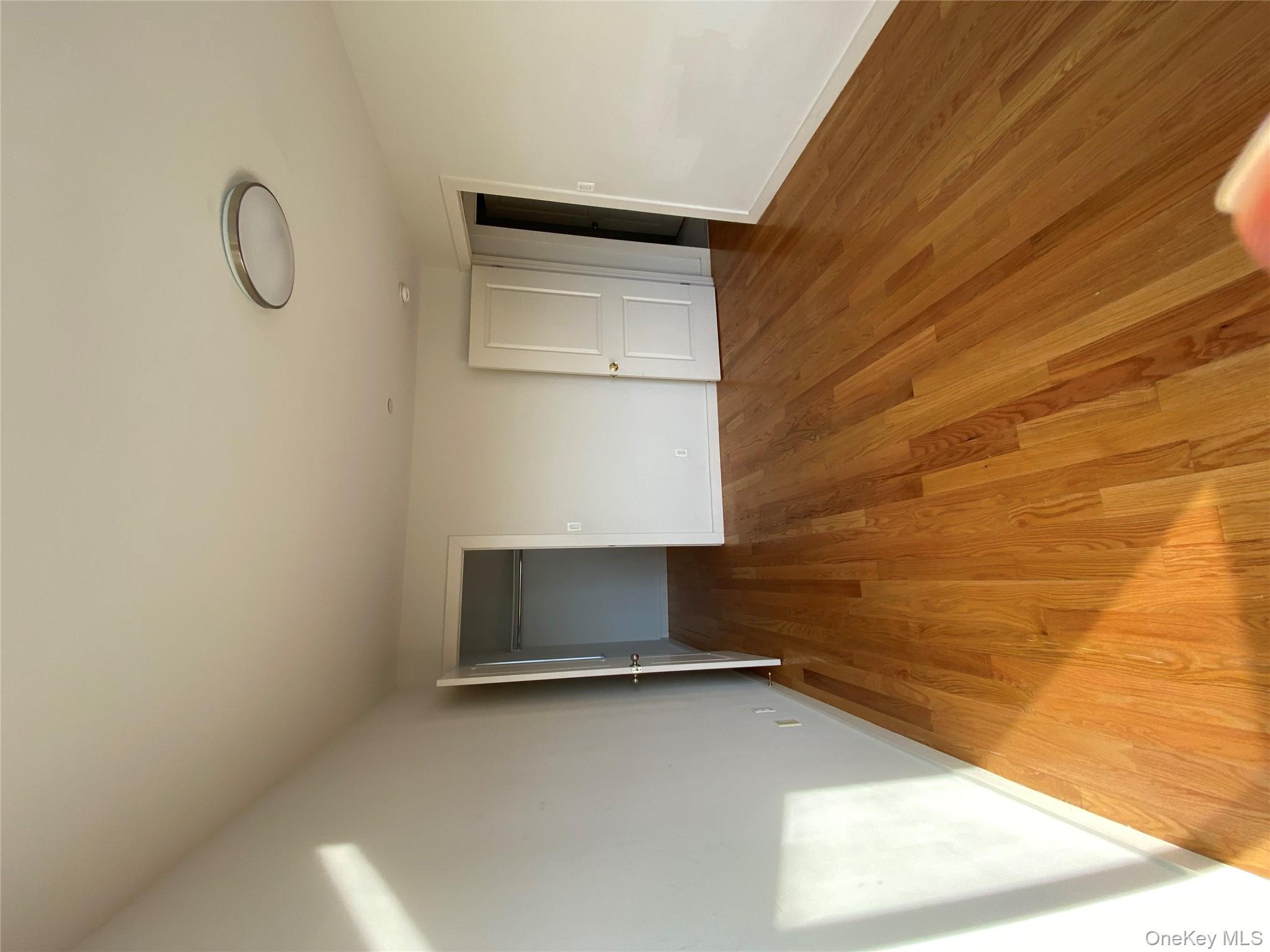 132-35 41st Road, Unit 10A Queens, NY 11355 - Photo 15 of 18 Unfurnished bedroom featuring light wood finished floors and a walk in closet