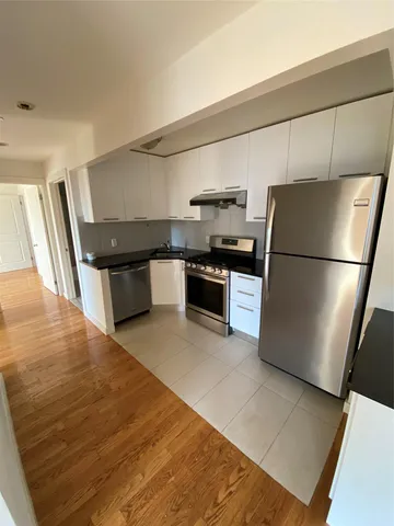 a utility room with wooden floor washer and dryer