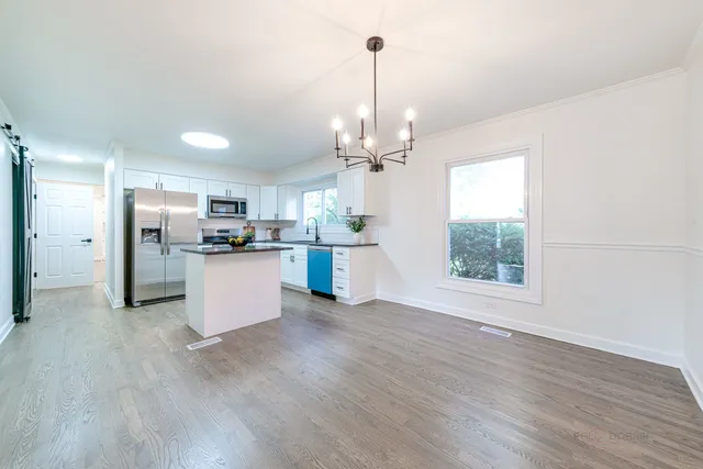 a view of kitchen and refrigerator with wooden floor