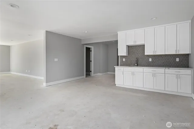 a kitchen with white cabinets and sink