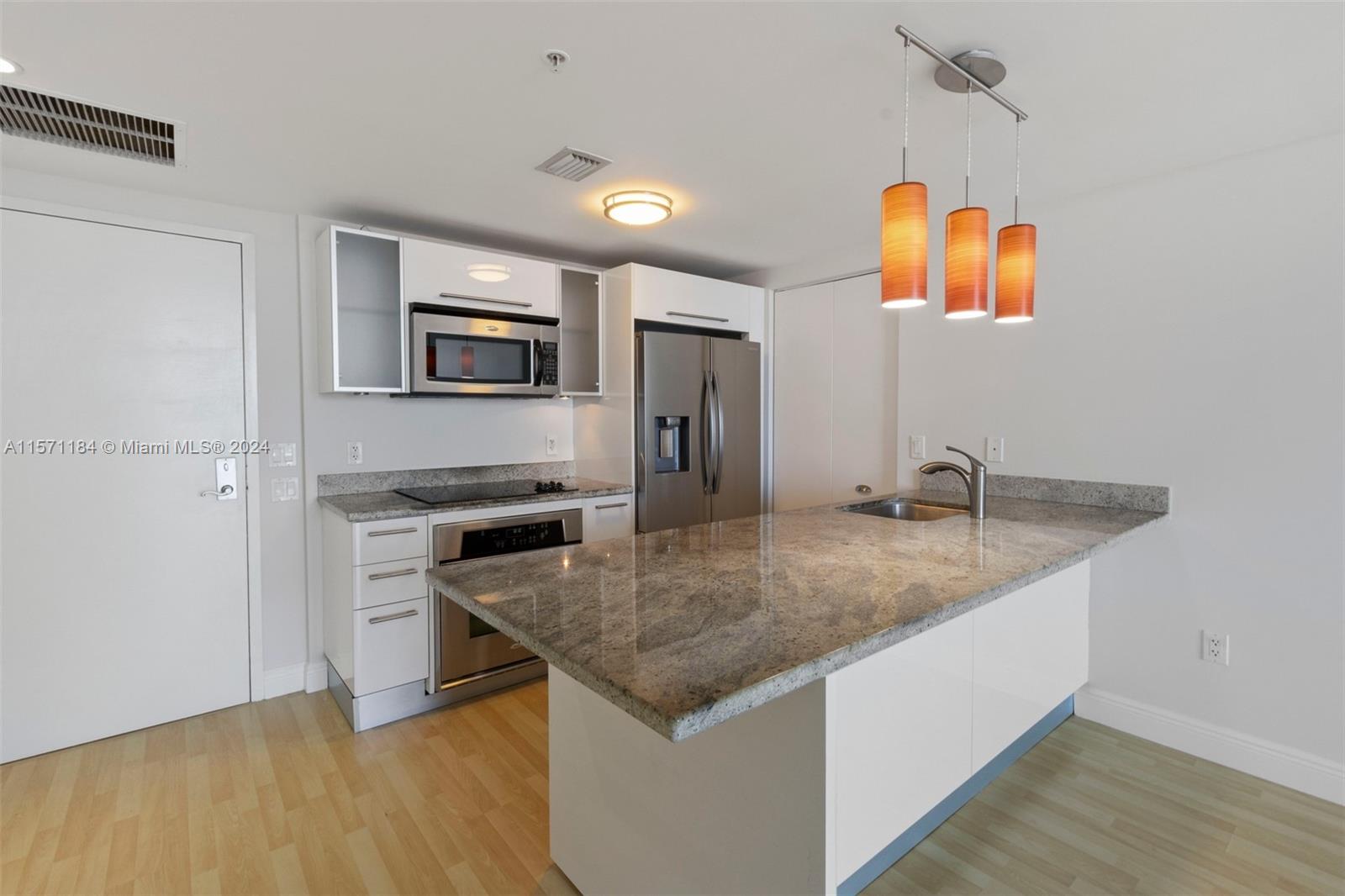 a kitchen with stainless steel appliances granite countertop a sink and a refrigerator