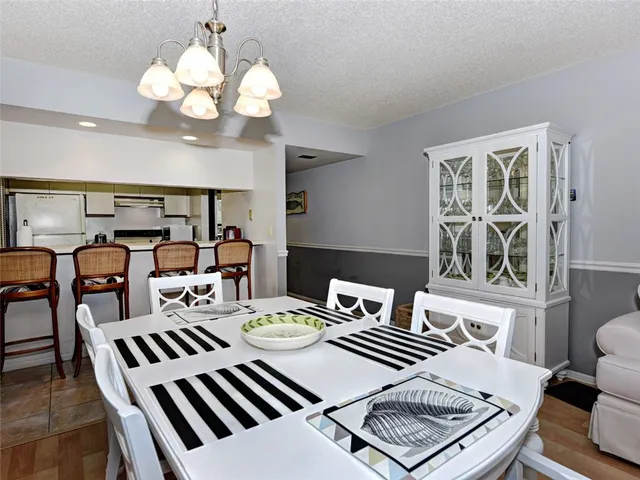 a view of a dining room with furniture a chandelier and wooden floor