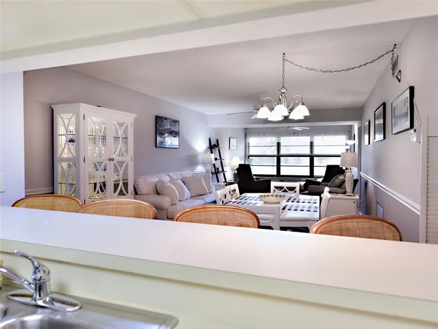 a living room with furniture a chandelier and a large mirror